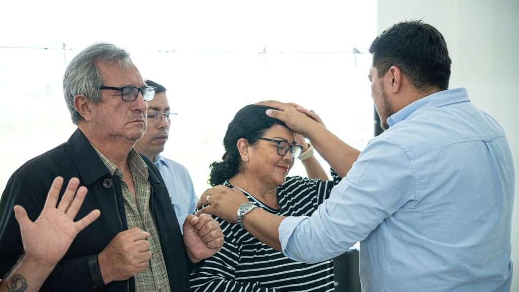 Equipo orando por una persona